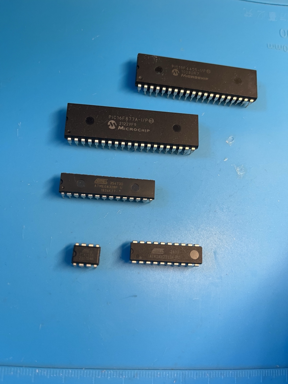 Microcontrôleurs PIC, ATmega328P et ATtiny photographiés pour un comparatif 2026